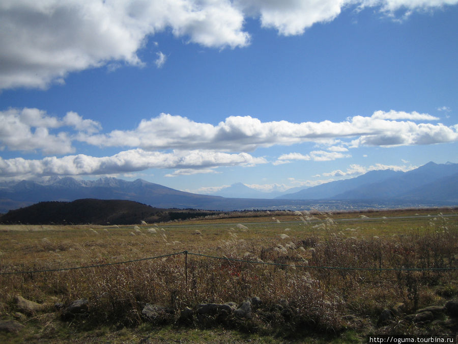 На задем фоне, посреди между двух гор на переднем плане, виднеется гора Фудзи. Тино, Япония