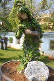 Статуя обвитая зелёными листьями