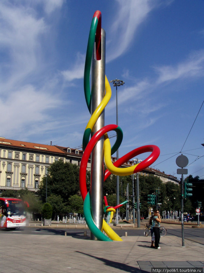 Здесь видны обе части скульптуры — игла и узелок на заднем плане через дорогу Милан, Италия