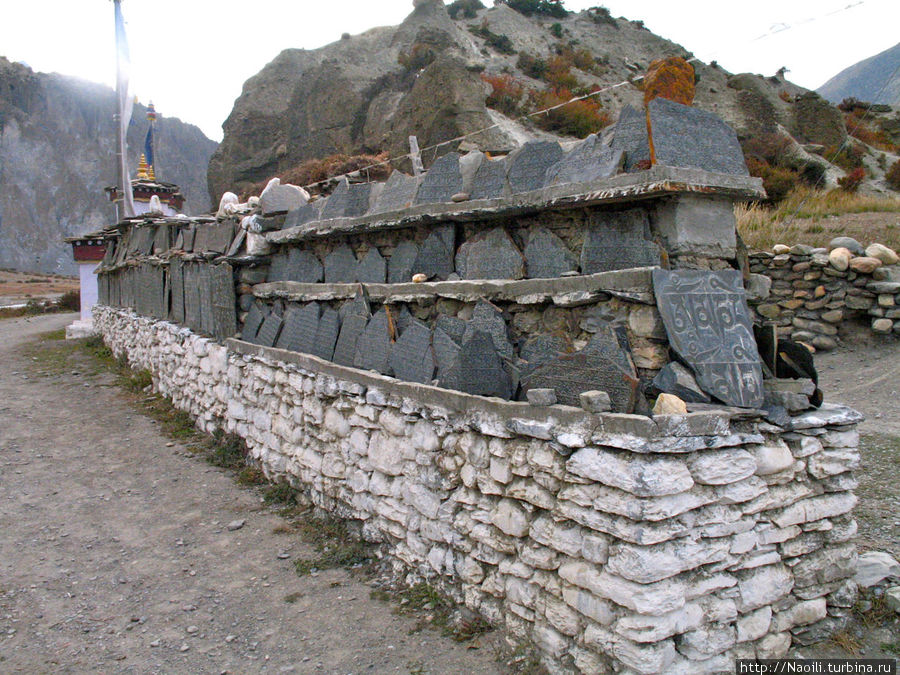 На постаменте рядом со входом выложены камни с вырезанными на них текстами молитв. Бхрага, Непал