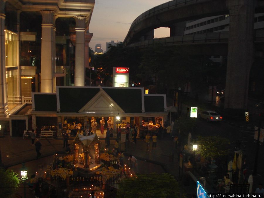 Вот как устроен один из перекрестков Банкгога: слева (мраморные колонны) начинается огромный торговый центр с фешенебельными магазинами; в центре — небольшой храм, около которого происходит какое-то религиозное действие; справа внизу — проезжая часть улицы, а справа вверху — метро, которое расположено над землей Таиланд