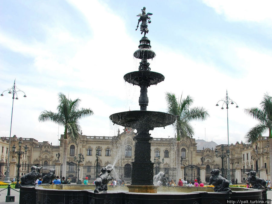 Традиционная для всех перуанских Пласа-де-Армас фигурка трубача на шпиле фонтана. Лима, Перу