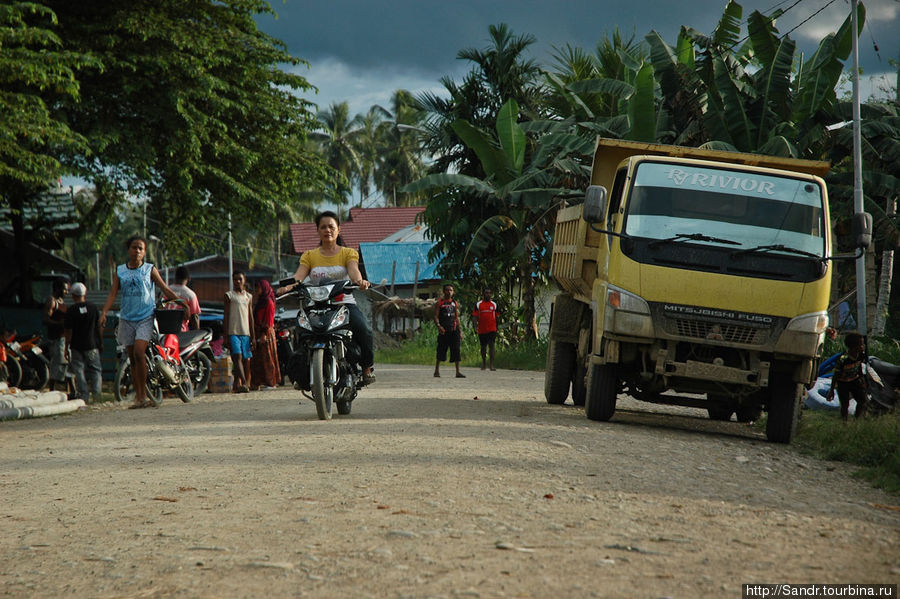 Зачем людям здесь мотоциклы мне непонятно. А вот грузовики, которых в поселке вроде шесть, используют для перевозки всех грузов. Папуа, Индонезия