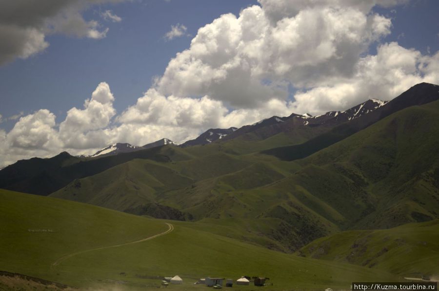 Вид с перевала Долон (3038 м). За машинами остается длинный шлейф пыли. Нарын, Киргизия