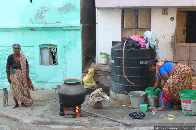Утренние постирушки с горячей водой! Воду кипятят рядом с баками Каньякумари, Индия
