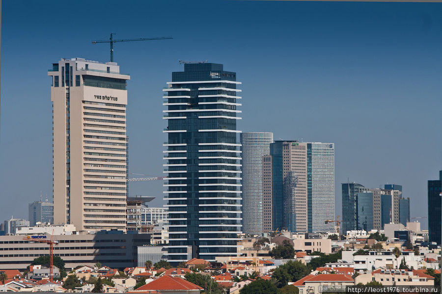 Высотки Тель-Авива. Вид со стороны старого Яффо. Левое здание — башня Мигдаль Шалом (полное Мигдаль Шалом Меир). Первый небоскреб Израиля.  До 1999 года в ней была смотровая площадка, но круглая башня Азриэли перетянула к себе посетителей и смотровую закрыли. В здании 34 этажа и высота его 142 метра. Когда его построили в 195 году это было самое высокое здание на Ближнем Востоке Тель-Авив, Израиль