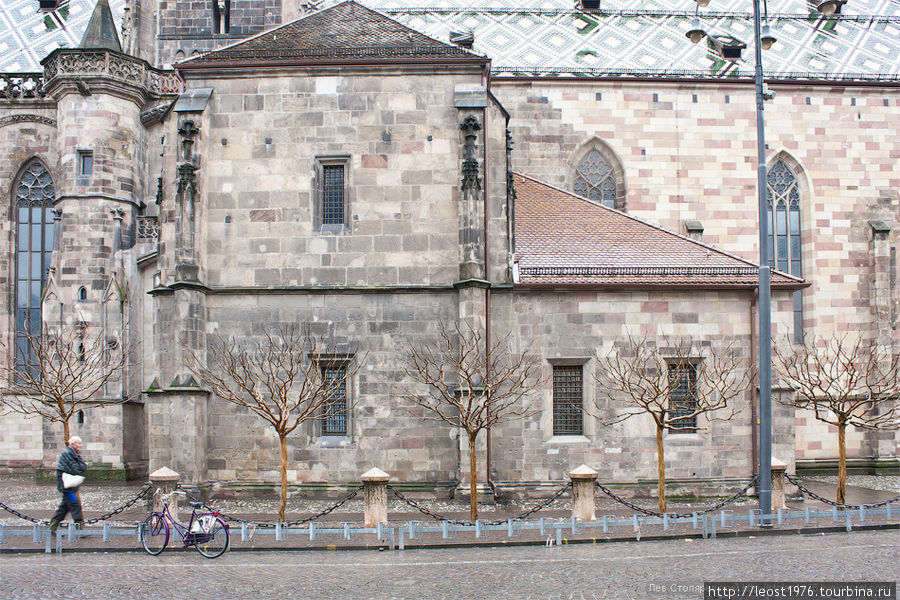 Стена собора, с сухими деревьями вдоль нее — у нас бы их спилили. Бользано, Италия