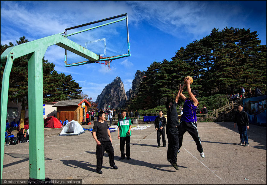 Те, кто нагулялся по горным тропам, развлекаются игрой в баскетбол на спортивной площадке Провинция Аньхой, Китай