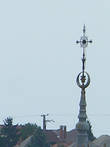 вершину которого украшает христианский крест вознёсшийся выше мусульманского полумесяца