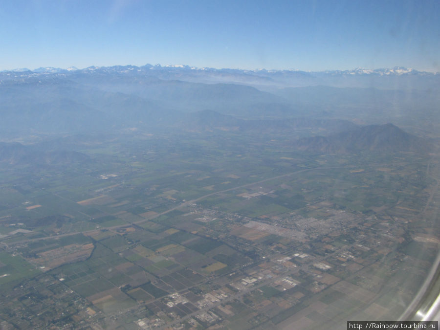 Плодородные земли в районе Сантьяго видные в дымке Чили