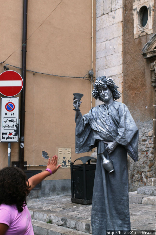 Живая статуя. Девушка испугалась, когда та предложила выпить — приняла ее за настоящую. Сицилия, Италия