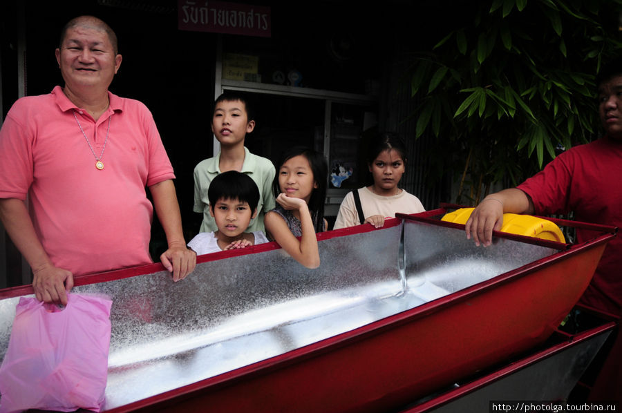 Семейство позирует рядом с лодкой, выставленной на продажу. Ходовой товар. Бангкок, Таиланд