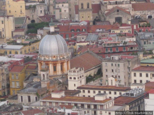 Массивный собор, совершенно пропадающий в плотно обступившей его застройке Неаполь, Италия
