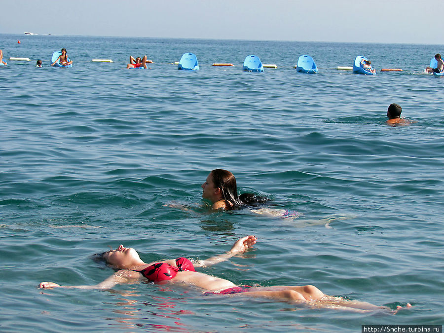 вдалеке очень интересные пластиковые лежаки на воде — только на нашем пляже Бечичи, Черногория