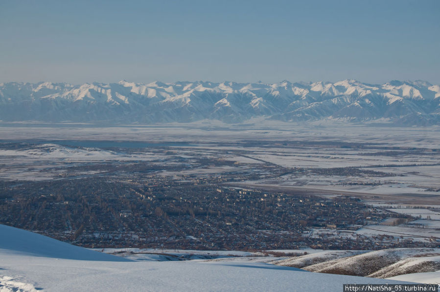 Вид с вершины на г. Каракол, позади озеро Иссык-Куль, и Северный Тянь-Шань. Будем спускаться с горы прямо к г. Караколу... Каракол, Киргизия