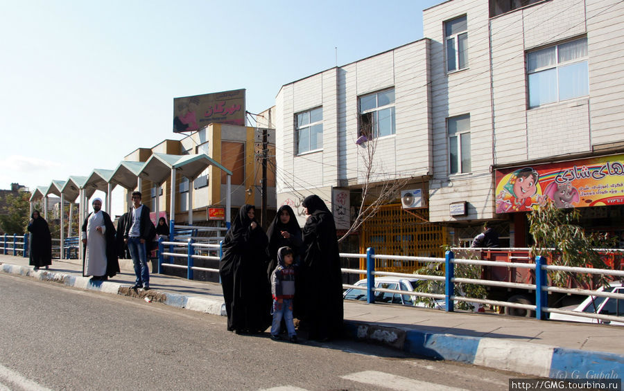 На улицах Кума. Женщины стоят отдельно, т.к. для них предусмотрен отдельный вход в женскую половину автобуса. Кум, Иран