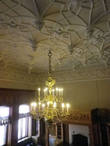 Две люстры зала выполнены в виде церковных паникадил. Двухглавые орлы Романовых украшают их.
