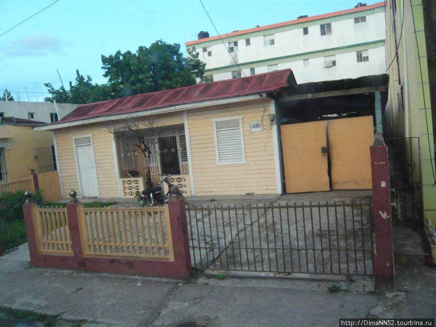 Наверное, домик среднего доминиканца. Есть мопед и решетки на окнах. Санто-Доминго, Доминиканская Республика