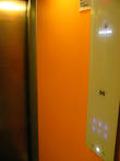 Лифт выдержан в оранжево-металлических тонах. Красиво.
