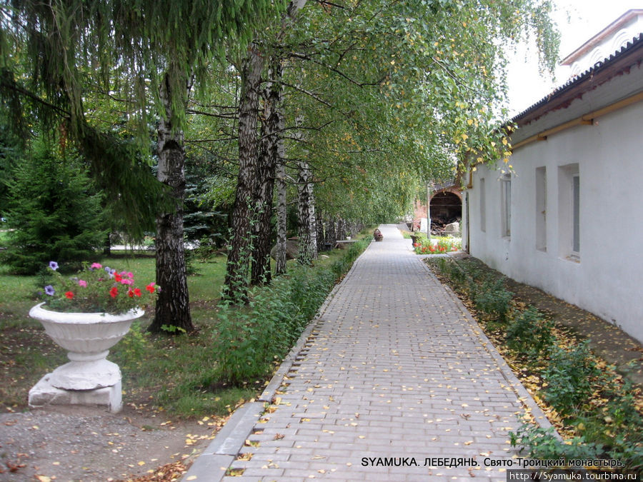 Тротуарная дорожка ведет к Троицкому храму. Справа — монашеские кельи. Лебедянь, Россия