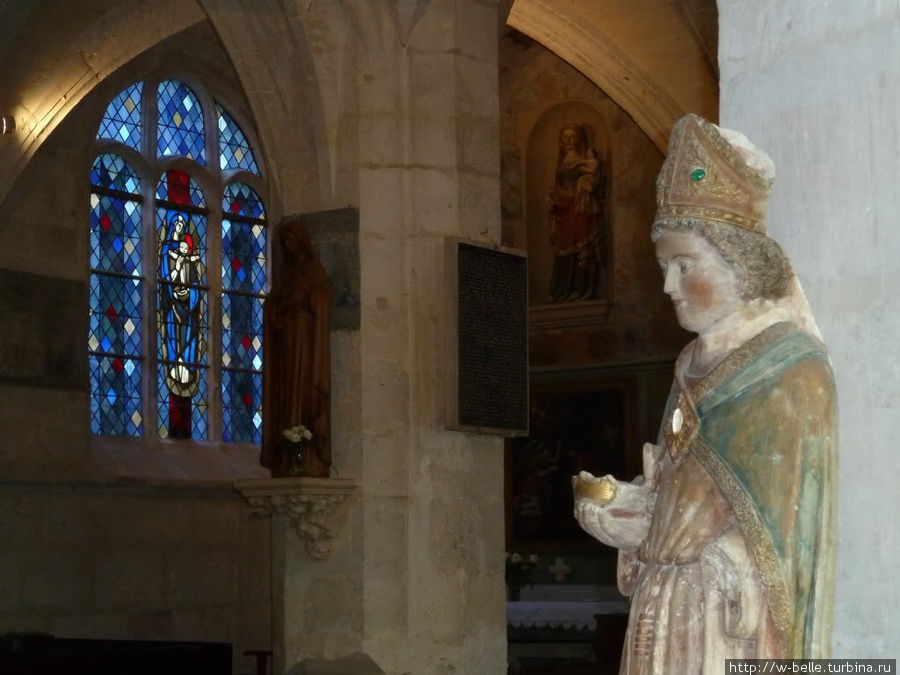 Внутреннее убранство церкви: витраж и статуя Луи Арагонского.