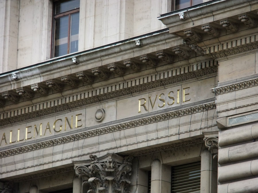 Фасад отеля Des Postes опоясан орнаментом , на котором золотыми буквами высечены названия разных стран. Женева, Швейцария