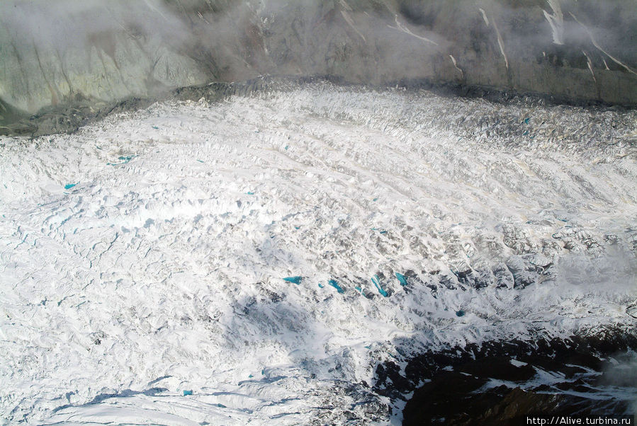 Скорость такого ледника — всего метр-два в год. Медленно, но верно он движется к океану. Маленькие голубые бусинки — это небольшие озерца чистой воды, которая то тает, то замерзает меж огромных торосов многовекового льда. Национальный парк Денали, CША
