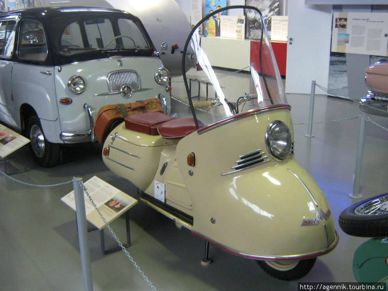 Maico Mobil 1953 год
Фирма «Майко Верк» (Maico-Werk), владельцами которой были братья Отто (Otto) и Вильгельм Майш (Wilhelm Maisch), с 1935 г. производила мотоциклы. В 1955 г. фирма приобрела у инженера Германа Хольбайна (Hermann Holbein), до войны работавшего на фирме БМВ (BMW), а позже занимавшегося проектированием и изготовлением гоночных автомобилей, лицензию на его двухместный заднемоторный автомобиль «Чемпион» (Champion) с двигателем рабочим объемом 250 см3. Но автомобиль оказался неконкурентоспособным среди других мотоколясок, выпускавшихся тогда в ФРГ. Тем не менее фирма «Майко» начала с модернизации «Чемпиона», оснастив его новым 2-цилиндровым двигателем фирмы «Хейнкель» (Heinkel) в 398 см3 и кузовом купе. Мюнхен, Германия