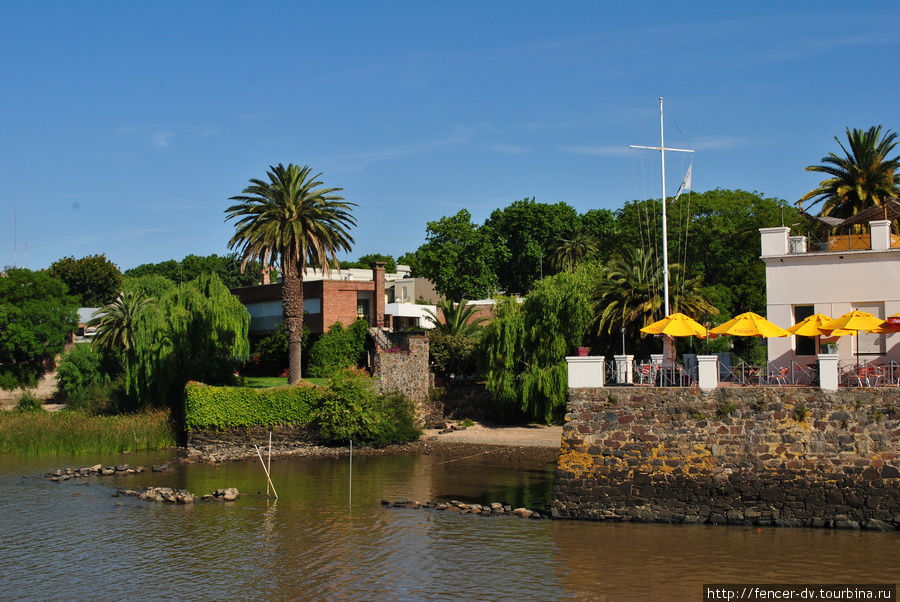 С уходящих в море пирсов город кажется утонувшим  в зелени Колония-дель-Сакраменто, Уругвай