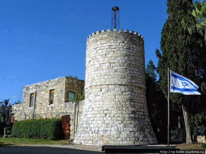 Здание старой водонапорной башни в мошаве, на которой установлен колокол. Йокнеам, Израиль