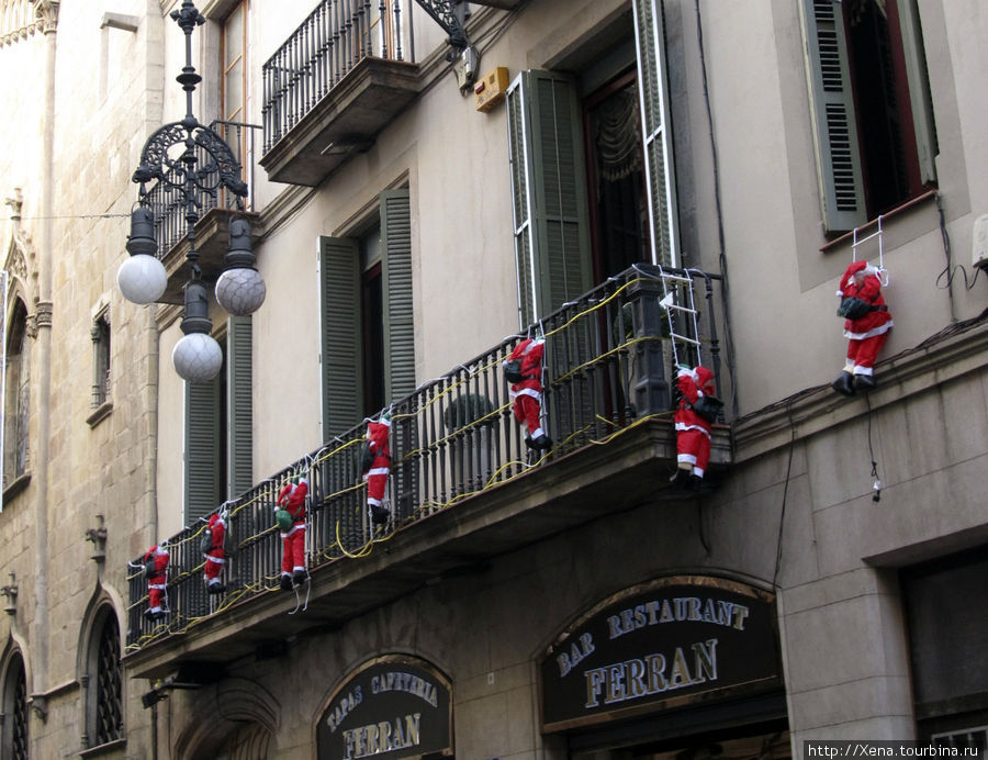 Традиционное украшение балконов — влезающие на них санты Барселона, Испания