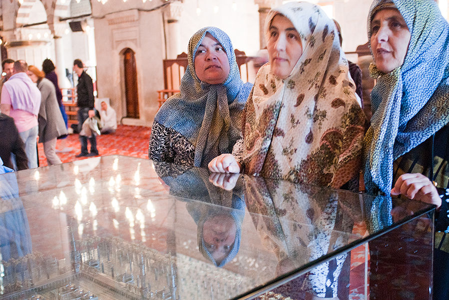 Женщины любуются картиной «Путешествие из Мекки в Медину». Стамбул, Турция