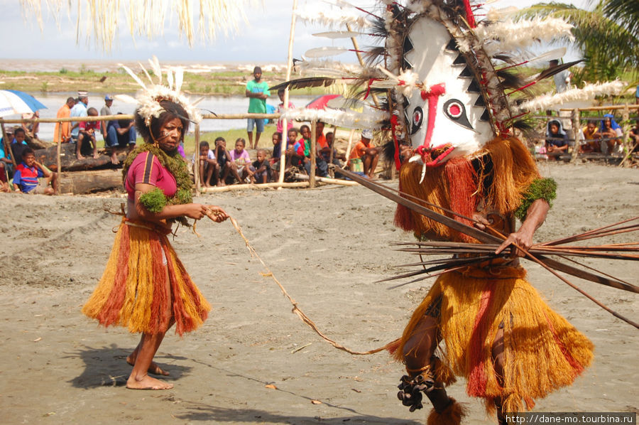 Девушка сопровождает маску, удерживая её на поводке Провинция Галф, Папуа-Новая Гвинея