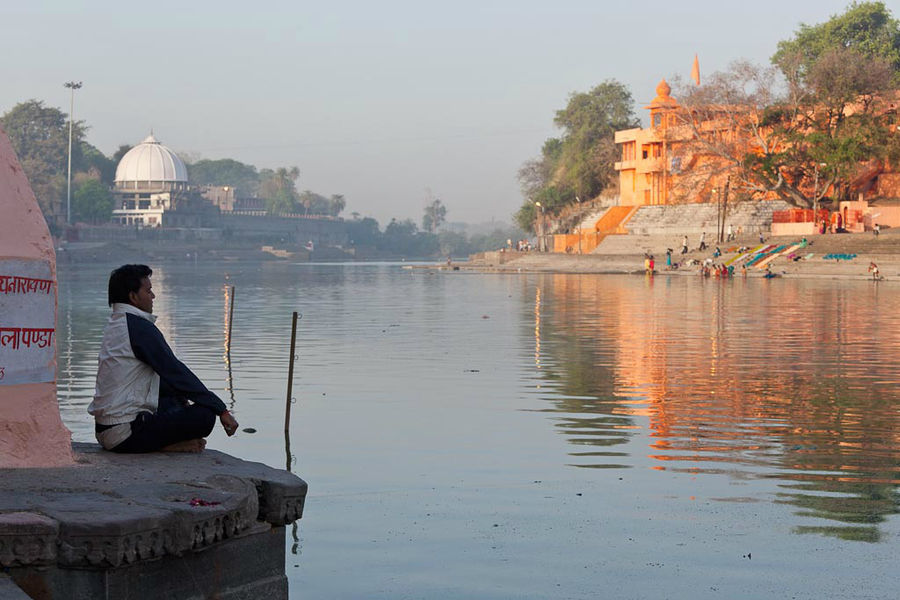Мужчина, медитирующий утром на берегу священной реки Шипра.  Удджайн, штат Мадхья Прадеш Индия