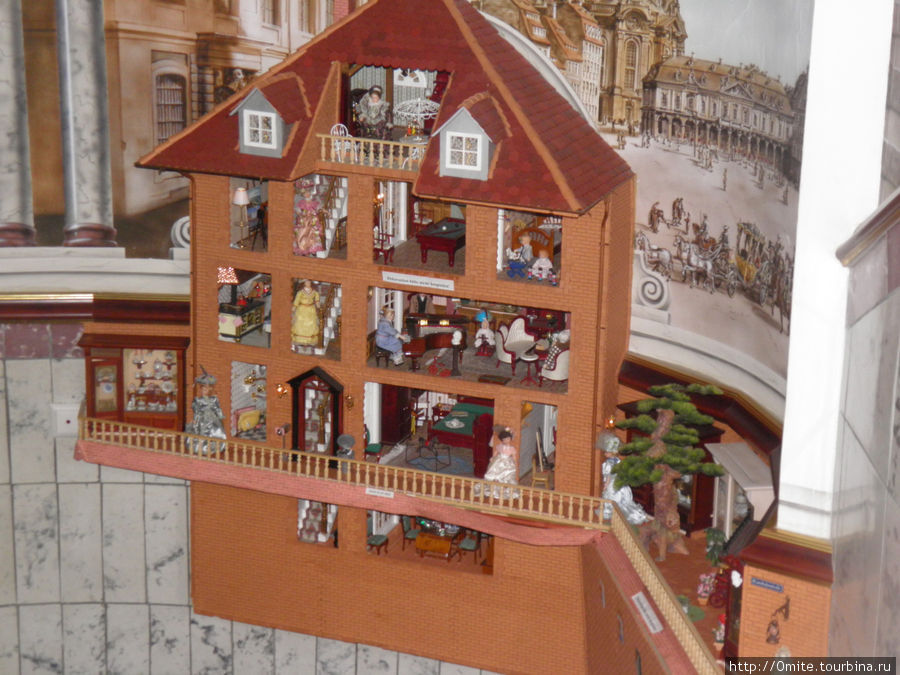 У входа стоит игрушечный кукольный домик. Дрезден, Германия