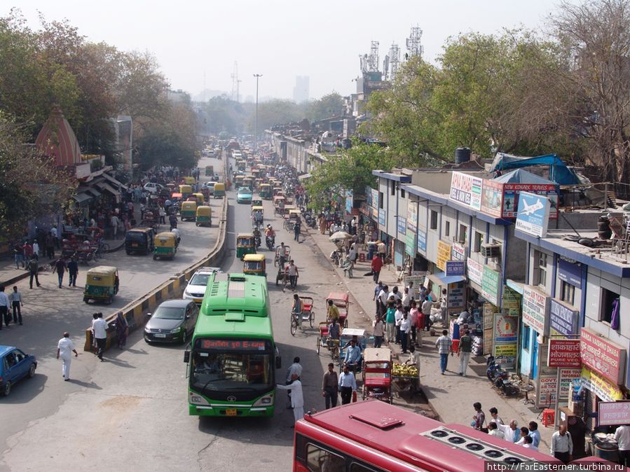 Улица перед вокзалом запружена людьми и машинами Дели, Индия