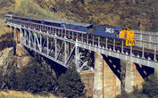 Поезд TranzAlpine проходит через виадук Broken River. Из фирменного журнала TranzScenic