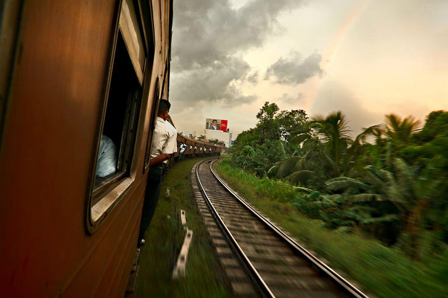 Поезд и радуга. Эта фотография со Шри Ланки, на пути из Коломбо в Канди. Люди висят на подножках не потому, что мест нет, а потому, что так веселее, и ветерок обдувает. Индия