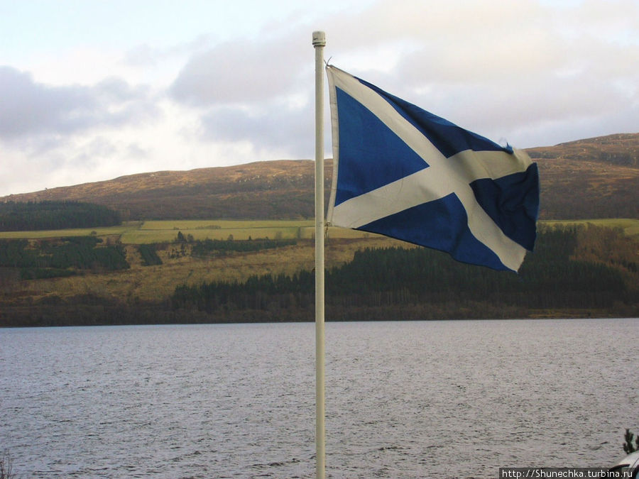 Шотландский флаг и воды озера Лох-Несс. Шотландия, Великобритания