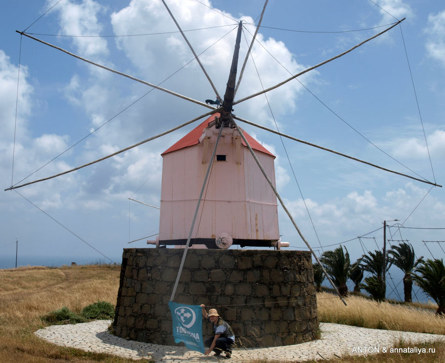 Ветряная мельница — символ Порту-Санту и Антон с флагом. Остров Порту-Санту, Португалия