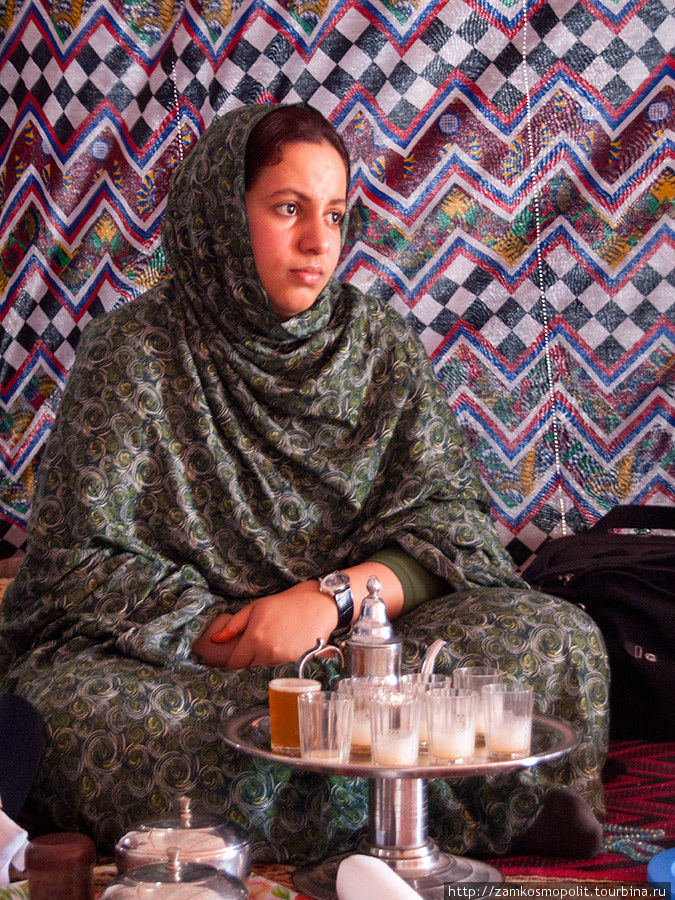 Девушка в традиционном наряде сахарави разливала по традиционным сахарским стаканчикам традиционный сахарский чай, который сахарави традиционно пьют с огромным количеством сахара. Дахла, Западная Сахара