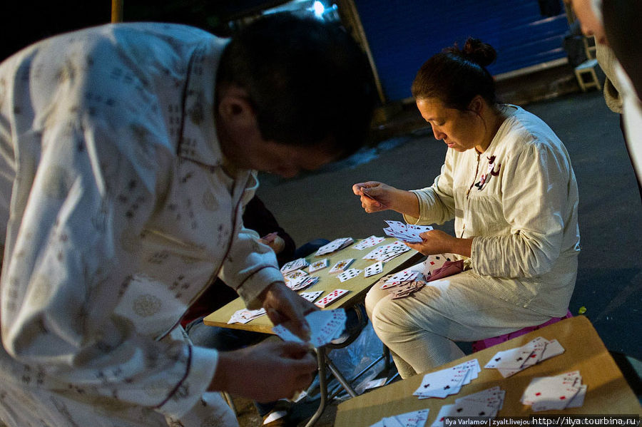 Люди в пижамах играют в карты на улице. Шанхай, Китай