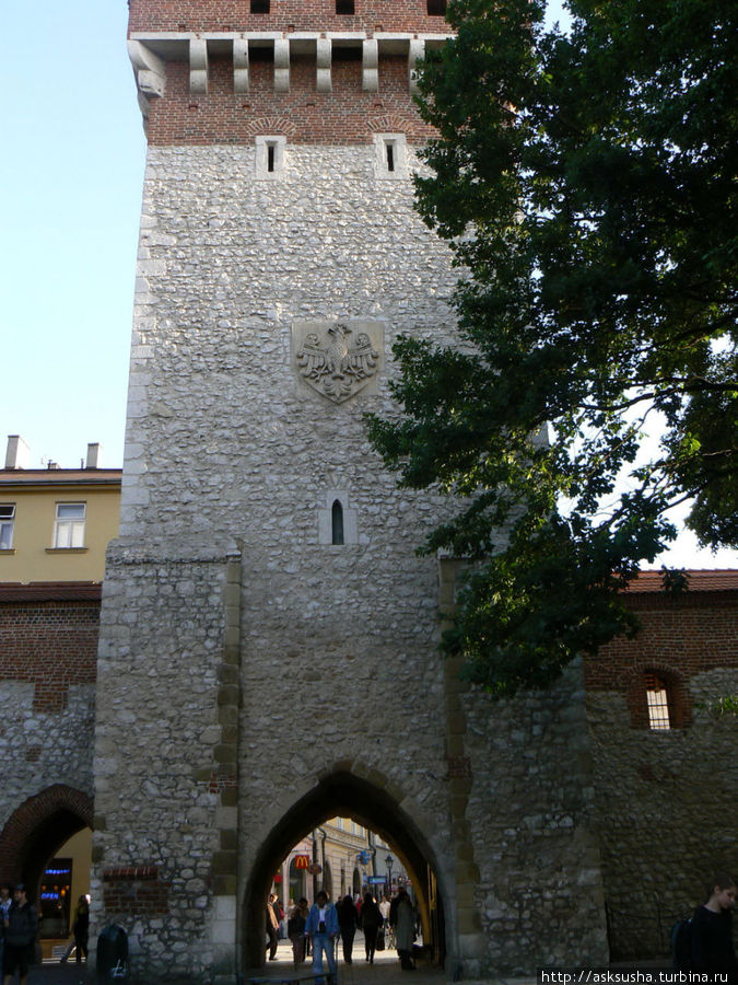 Флорианские ворота, впервые упомянутые в 1307 г., посвящены св.Флориану, патрону Кракова. Въезные ворота расположены в квадратной башне. На фасаде башни изображен геральдический орел. Краков, Польша