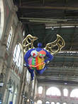 В здании ж/д вокзала под потолком парит голубой ангел.