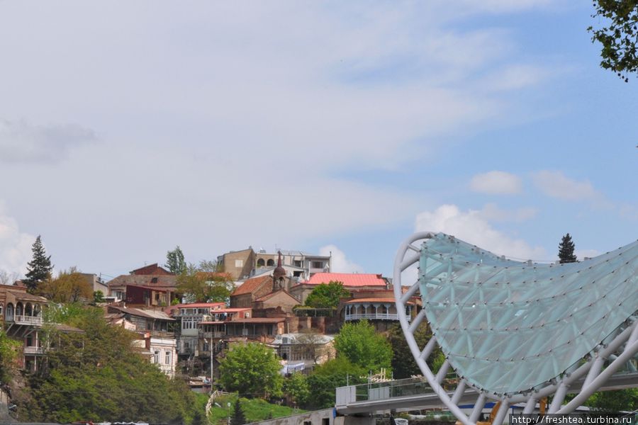 С набережной Бараташвили отмечаем контрасты Тбилиси: за рекой, на левом берегу, лежит колоритный район Авлабари, а справа виднеется конструкция ажурного пешеходного моста Мира, что открылся в мае 2010. Тбилиси, Грузия