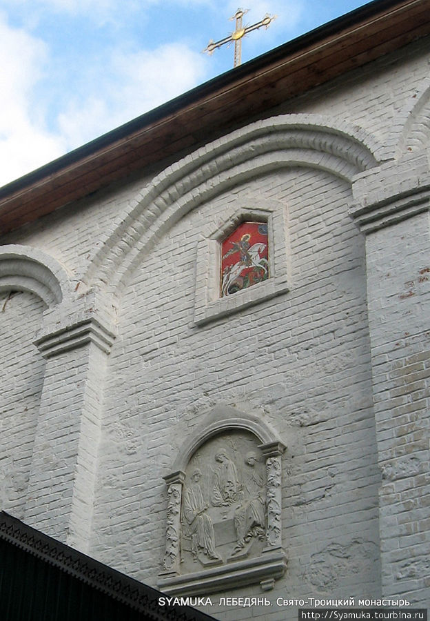 На фасаде из белого камня восстановлены икона Святой Троицы и мозаичная икона Георгия Победоносца. Лебедянь, Россия