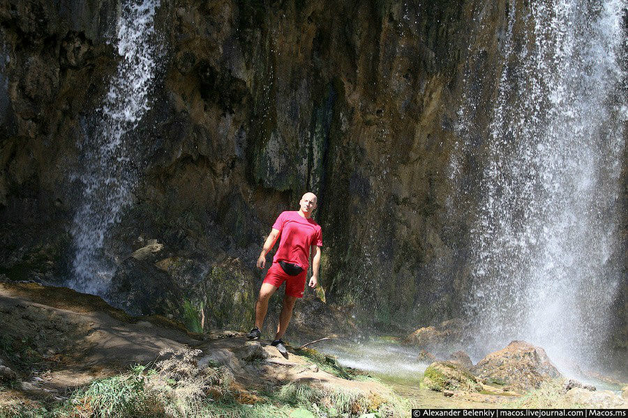 Огромный лысый немец ебашит лук на фоне водопада. Национальный парк Плитвицкие озёра, Хорватия