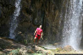Огромный лысый немец ебашит лук на фоне водопада.