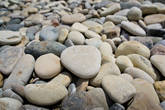 Вот такими симпатичными округлыми камнями разных цветов — белые, розовые, серые, зеленоватые, темно-серые и пр. — усеян пляж