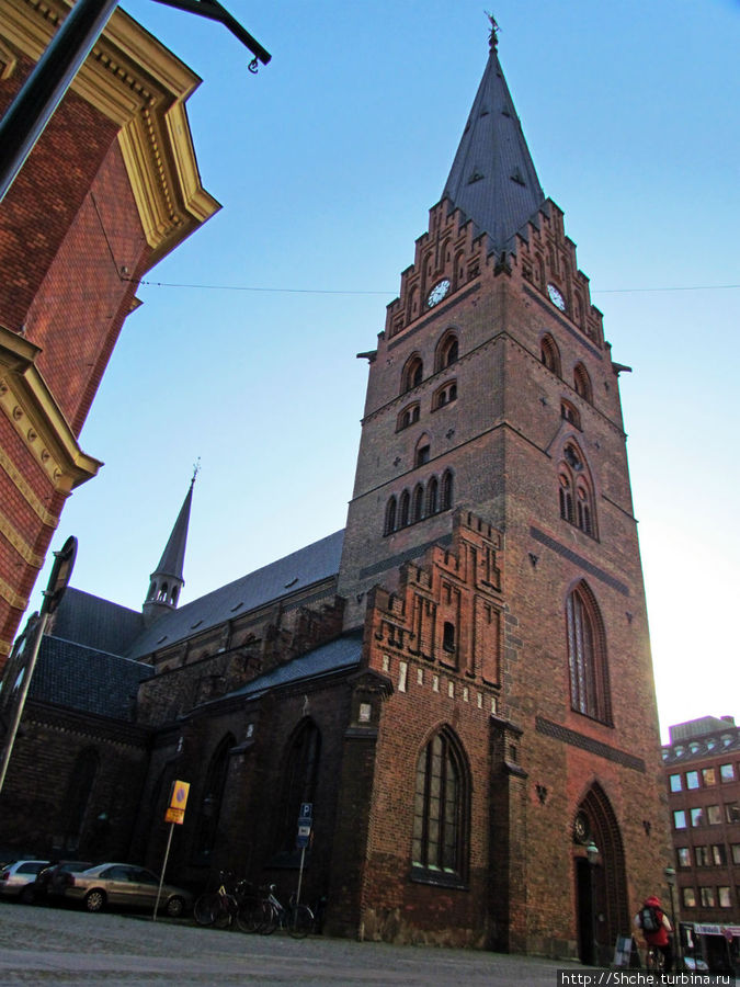 Перед церковью узкая улица, и трудно найти место, откуда в кадр попадает все строение Мальмё, Швеция